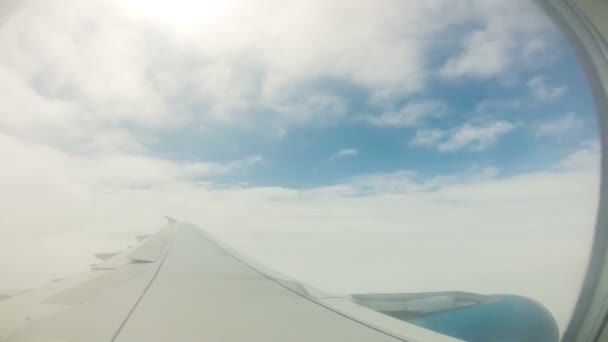 View of blue sky and wing of plane flying through clouds, Time Lapse — Stock Video