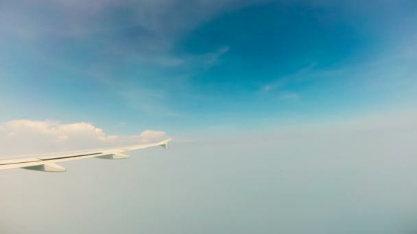 Blick auf blauen Himmel und Flugzeugflügel, der durch Wolken fliegt, Zeitraffer — Stockvideo