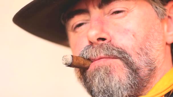 カウボーイ喫煙葉巻のクローズ アップの肖像画。白い背景の上 — ストック動画