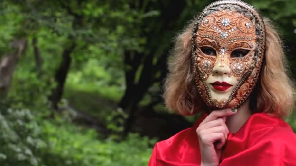 Mooie vrouw in carnaval masker over gebladerte achtergrond — Stockvideo