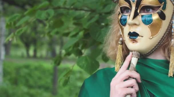 Mooie vrouw in carnaval masker over gebladerte achtergrond — Stockvideo