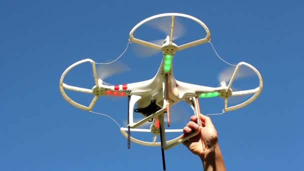 Quadrocopter přelétají nad nimi proti modré obloze — Stock video