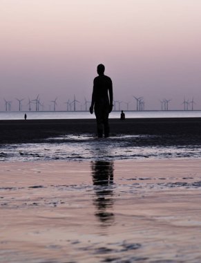 Antony Gormley 'nin Liverpool yakınlarındaki Crosby Sahili' nde 2021 Nisan 'ında yakalanan 100 Demir Adam heykelinden üçü..