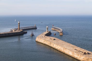 İki uzun liman iskelesinin arasından Whitby 'den çıkan tekne..