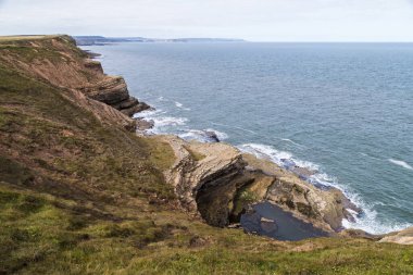 Filey Brigg 'in engebeli uçurumlarında Scarborough' la birlikte geniş bir su havuzu..