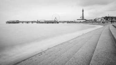 Blackpool Kulesi ve Merkez İskelesi tek renkli basamaklar boyunca şehri İrlanda Denizi 'nden korumak için sahilin kenarını kaplayan basamaklar boyunca görüldü...