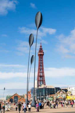 Turistler, Eylül 2021 'de limandaki Blackpool Kulesi ve Blackpool RNLI binası gibi dört dev kaşık heykelinin altında görüldü..