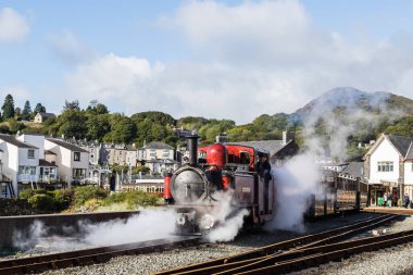 FR Double Fairlie Ekim 2021 'de Kuzey Galler kıyı şeridinde Porthmadog' dan ayrılmaya hazırlanırken dumanı tütüyor..