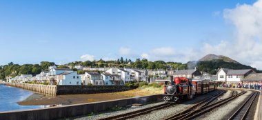 Porthmadog 'daki Double Fairlie buhar treninin panoraması istasyondan ayrılmaya hazırlanıyor. Kuzey Galler 'de Ekim 2021' de çekilmiştir..