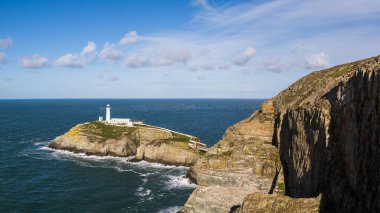Kuzey Galler 'de Anglesey sahilinde Ekim 2021' de kayalık bir uçurum üzerinde denize açılan Güney Yığını Deniz fenerinin çoklu görüntüsü..