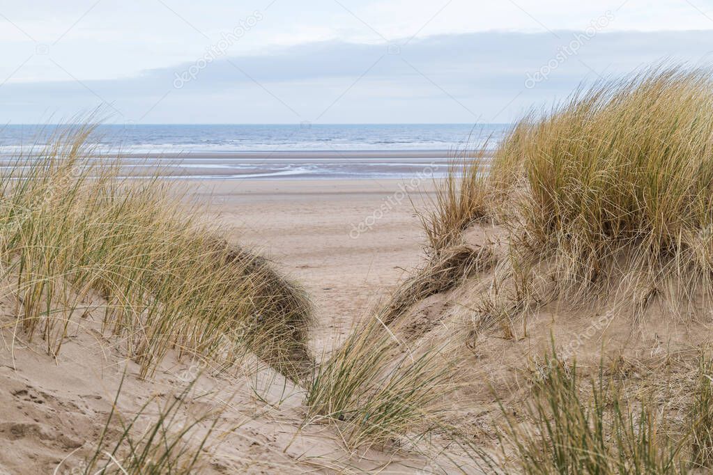 The Irish Sea seen between a pair of sand dunes on the coastline at Formby near Liverpool.