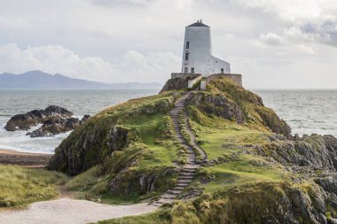 Adımlar, Ekim 2021 'de Anglesey sahilindeki Llanddwyn Adası' nın engebeli kayalıkları üzerindeki Büyük Kule 'ye çıkıyor..