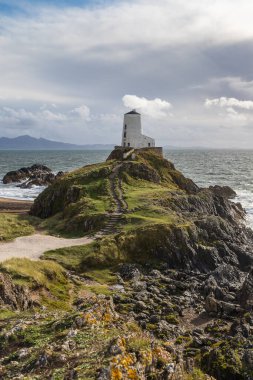 Twr Mawr olarak da bilinen Büyük Kule, Ekim 2021 'de Llanddwyn Adası' nın kayalık kıyısında güneş tarafından aydınlatıldı..
