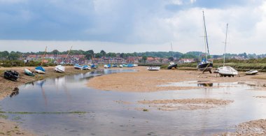 Blakeney 'e giden kanal, Haziran ayında Kuzey Norfolk sahilinde alçak gelgitle karaya vurmuş küçük balıkçı tekneleriyle dolu..
