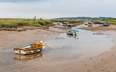 Kuzey Norfolk sahilinin alçak gelgitinde Blakeney 'deki bir su kanalına demirlemiş tekneler Haziran 2021' de resmedildi..