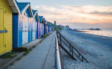 Cromer sahil şeridinin doğu sahilinde Kuzey Norfolk kıyısındaki iskeleye uzanan şirin sahil kulübeleri, Haziran 2021 'de resmedildi..