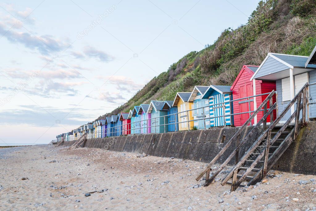 Colourful beach huts line the promenade at Cromer before sunset on the North Norfolk coast in June 2021.