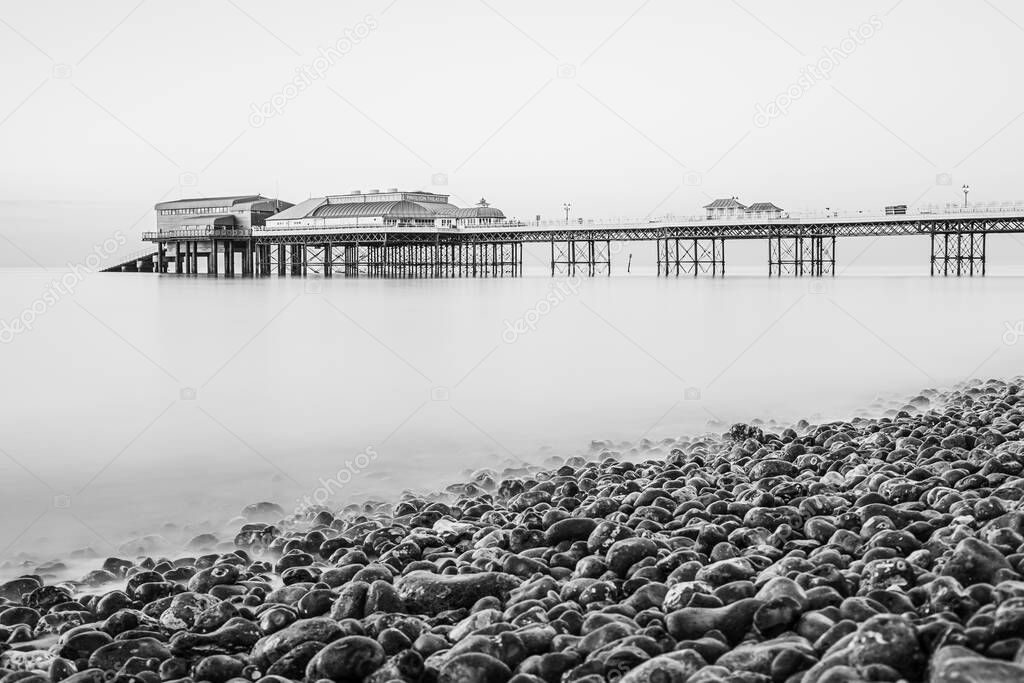 Cromer pier seen over the pebble beach in a long exposure taken in June 2021 on the North Norfolk coast.