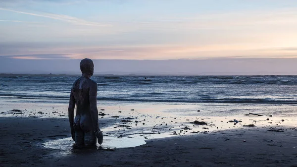 2022年1月にリバプール近郊のクロスビービーチで潮が近づいてくるのを見ながら アントニー ゴームリーが制作した鉄の男像の風景 — ストック写真