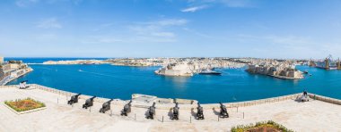 Nisan 2022 'de Malta' da St. Angelo Kalesi, Gardjola Bahçeleri ve Kalkara Marina 'ya bakan Valletta silueti üzerindeki selamlama bataryasının çoklu görüntü panoraması.