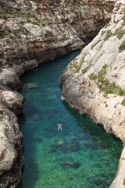 Nisan 2022 'de Malta' nın Gozo adasındaki dar Wily il-Ghasri vadisinde yüzen genç bir kadın..