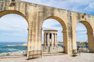 Nisan 2022 'de Malta Valletta' daki Aşağı Barrakka Bahçeleri 'nin kemerlerinden görülen Kuşatma Çanı Savaşı Anıtı..