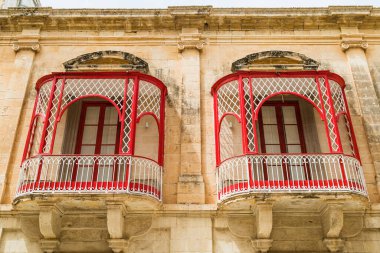 Nisan 2022 'de Malta' nın eski başkenti Mdina 'da görülen bir çift güzel kırmızı balkona bakıyorum..
