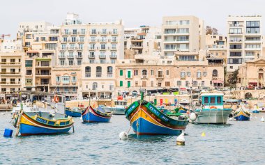 Colourful boats moored in Spinola Bay near to the Malta capital city of Valletta in April 2022.