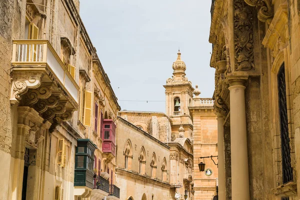 Renkli cadde 2022 Nisan 'ında Malta, Mdina' daki Meryem Ana 'nın duyurusu Kilisesi' nin çan kulesine doğru gidiyor..
