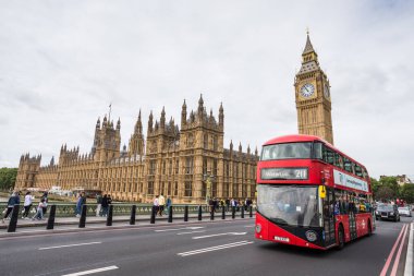 Mayıs 2022 'de Londra Parlamentosu önünde Westminster Köprüsü' nden geçen kırmızı bir Londra otobüsü görülüyor..