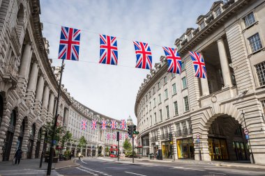Union Jack flags hang above Regent Street leading away from Piccadily Circus in May 2022 as London prepares for the Queens Platinum Jubilee celebrations. clipart