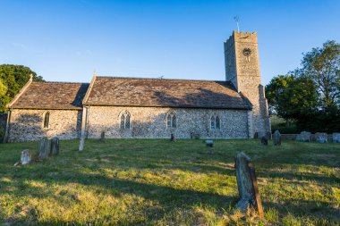 Golden light spills onto St James Church in Dunwich on the Suffolk coast seen in July 2022.