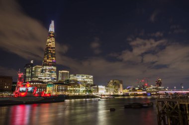 St Georges flag illuminated on The Shard seen above HMS Belfast lit up in red, both in celebration of England winning the 2022 UEFA European Women's Football Championship seen in London in July 2022.