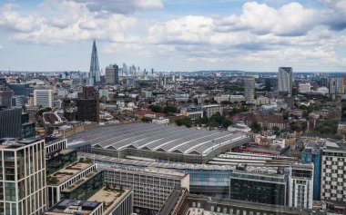 Looking down on Waterloo train station from the London Eye in August 2022.  The Shard and further back still Canary Wharf can be seen in the background peaking above the London skyline.