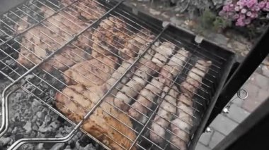 Güzel sulu et parçaları sıcak barbekü kömürlerinin üzerinde tel askıda kızartılır. Yüksek kaliteli FullHD görüntüler