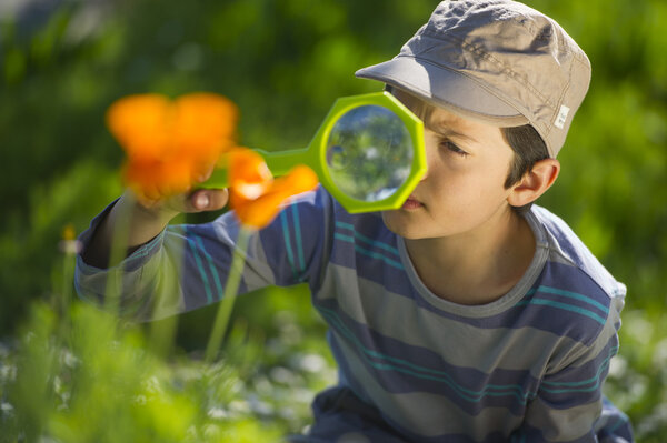Child observing nature with a magnifying glass