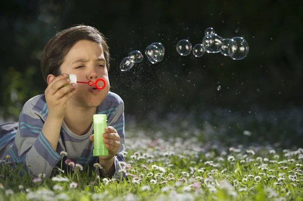 Niño jugando a soplar burbujas de jabón —  Fotos de Stock