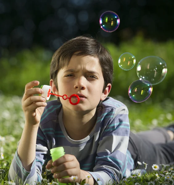 Niño jugando y soplar burbujas de jabón — Foto de Stock