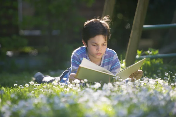 Criança lendo um livro ao ar livre — Fotografia de Stock