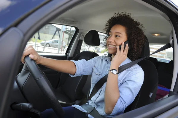 Young woman phoning and driving a car — Stock Photo, Image