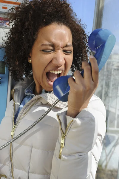 Young woman in a phone booth — Stock Photo, Image