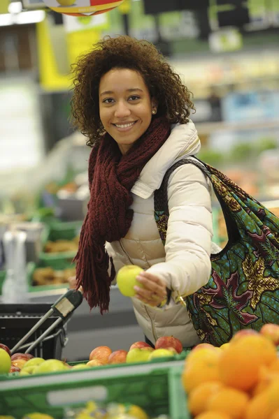 La mujer compra fruta y comida en el supermercado —  Fotos de Stock