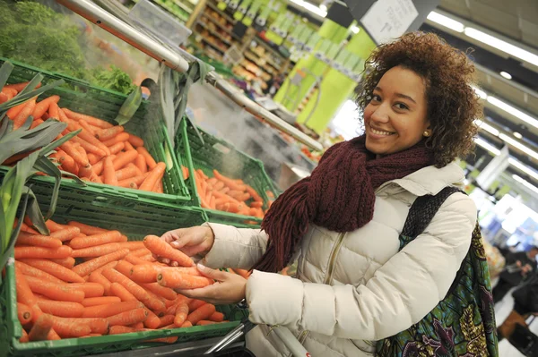 Frau kauft Karotten und Lebensmittel im Supermarkt — Stockfoto