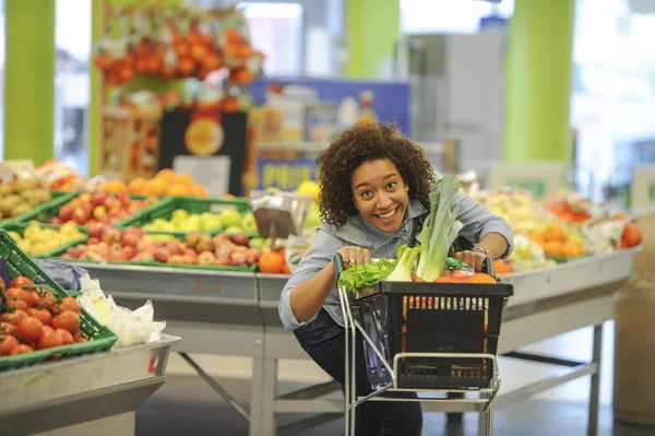 Mujer compra verduras y alimentos en el supermercado —  Fotos de Stock