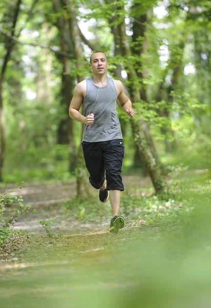 Jeune homme courant dans les bois — Photo