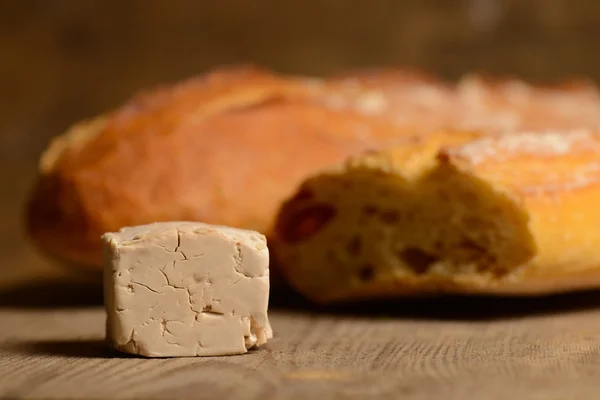 Yeast and bread on wood — Stock Photo, Image