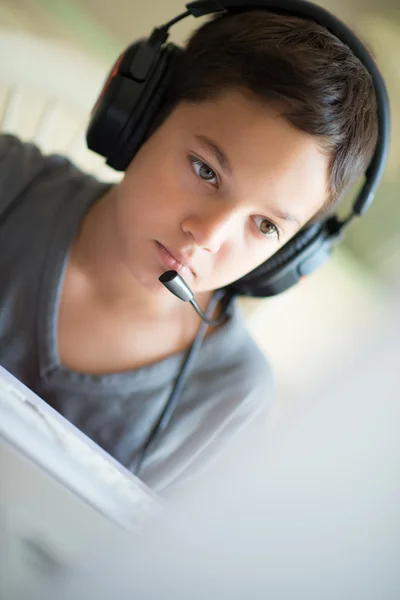 Niño jugando en el ordenador con auriculares — Foto de Stock