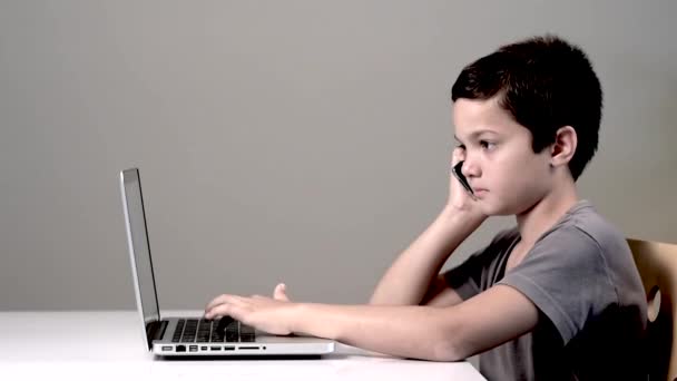 Niño pequeño en el teléfono y el ordenador portátil — Vídeo de stock