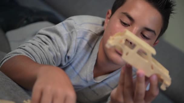 Niño haciendo el montaje de un modelo de coche en casa — Vídeos de Stock