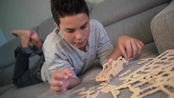 Niño haciendo el montaje de un modelo de coche en casa — Vídeo de stock